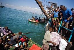 Local citizens try to flee this destroyed city by boat in Port-au-Prince, Haiti, Jan. 20, 2010. (Xinhua/David de la Pas)