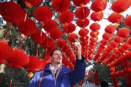 A foreigner takes handy phone snapshot inside the long corridor decorated with full range of florid red lanterns in the Ditan (Altar of the Earth) Park, as the festival atmosphere for the 25th Spring Festival Temple Fair, slated from February 13 to 20, at Ditan Park is drumming up, in Beijing, February 4, 2010. A foreigner takes handy phone snapshot inside the long corridor decorated with full range of florid red lanterns in the Ditan (Altar of the Earth) Park, as the festival atmosphere for the 25th Spring Festival Temple Fair, slated from February 13 to 20, at Ditan Park is drumming up, in Beijing, February 4, 2010.
