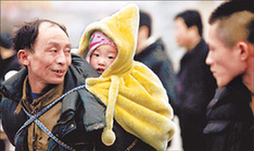 Chen Mingshu (left), 47, takes his two-year-old granddaughter back to their hometown in Sichuan province, at the Beijing Railway Station yesterday.