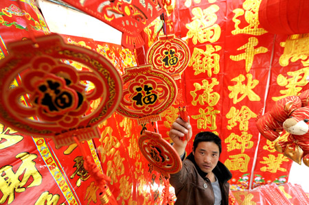 A Han Chinese chooses new year decorations at a market in Lhasa, capital of southwest China's Tibet Autonomous Region, on Feb. 8. 