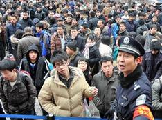 A staff member leads stranded passengers at a long-distance bus station in Taiyuan, north China's Shanxi Province, on Feb. 10, 2010. Several expressways in Shanxi were closed and the long-distance bus services in Taiyuan were suspended due to the heavy snow hitting the northern province on Tuesday night, local transport authorities said. [Xinhua]