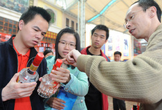 Consumers learn to distinguish genuine liquor from the fake version during a consultation activity held for the annual World Consumer Rights Day in Foshan, south China's Guangdong Province. [CFP Photo]