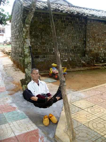 Hainan village life relies heavily on the natural environment. One popular way of relaxing is in a hammock made from a fishing net. Tourists can spend the night in a village to get a feel for local island life. [Suzi Tart/China.org.cn] 