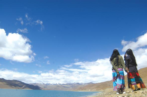 An undated photo shows two visitors doing sightseeing by the Yamdrok Yumtso Lake in Shannan Prefecture, southeastern Tibet.[Photo: Lhasa Evening News] 