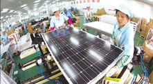 Workers from a solar energy company in Nantong, Jiangsu province, operate a production line to produce solar cells. [China Daily]