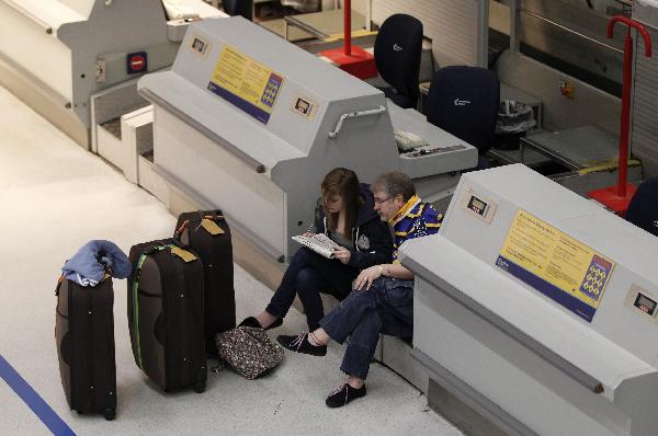 Passengers wait, after flights were disrupted, in a terminal in Manchester Airport, Manchester northern England April 15, 2010. Flights in and out of Britain were disrupted on Thursday after a cloud of volcanic ash drifting across Britain from Iceland closed several airports, with flights cancelled at London's Heathrow, Gatwick and other airports. [Xinhua]