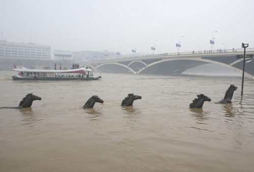 Water rises to its highest level this year in the Guilin section of Lijiang River in the Guangxi Zhuang autonomous region on Monday, submerging statues on a pedestrian pathway along the river as a result of continuous rainfall. Rainfall in the past days in Guangxi, Yunnan and Guizhou has eased the prolonged drought in Southwest China. [Xinhua]