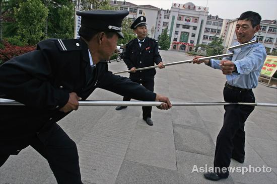 Security guards contain an attacker with specially designed forks in a mocked attack in Dongming Middle School in Weifang, East China's Shandong province May 2, 2010.