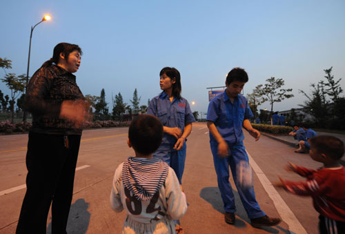 Zhao (middle) and Xu (right) talk to a colleague while taking a walk with their son in Hangzhou, East China's Zhejiang province, May 25, 2010. 