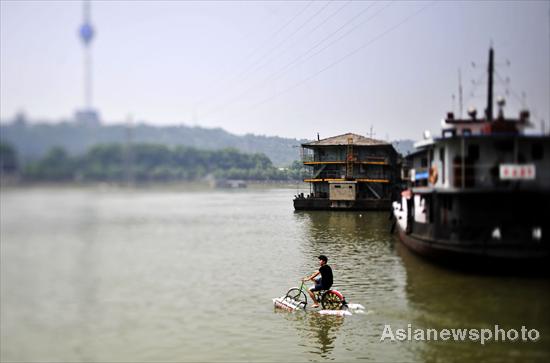  A man rides across the Hanjiang River (a tributary of the Yangtze) in Wuhan, capital of Central China&apos;s Hubei province on June 16, 2010. [Asianewsphoto] 