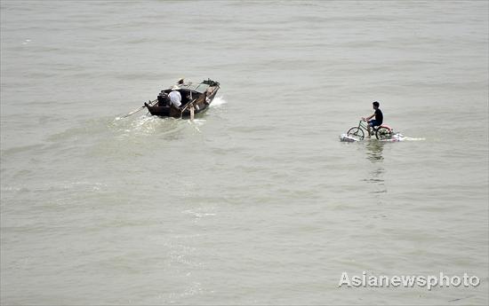 A man rides across the Hanjiang River (a tributary of the Yangtze) in Wuhan, capital of Central China&apos;s Hubei province on June 16, 2010. [Asianewsphoto] 