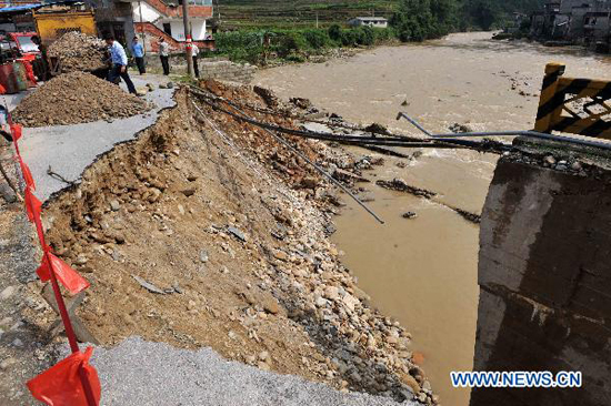 Villagers stand by a bridge broken by flood in Liaohe village in Rongshui Miao Autonomous County, southwest China's Guangxi Zhuang Autonomous Region, June 18, 2010. Villagers stand by a bridge broken by flood in Liaohe village in Rongshui Miao Autonomous County, southwest China's Guangxi Zhuang Autonomous Region, June 18, 2010.