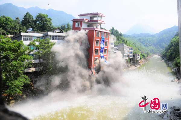 A seven-story illegal building is demolished by a blast along a river in Hefeng County, Central China&apos;s Hubei province on July 29, 2010. [CFP] 