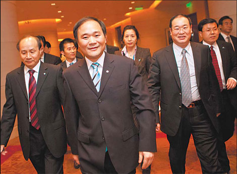 Li Shufu (center), chairman of Zhejiang Geely Holding Co, arrives for a news conference in Beijing earlier this year. The Geely-Volvo deal has won approval from the Chinese government. [Photo/Bloomberg]