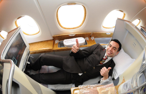 A steward gestures as he shows the interior design in business class of the Emirates Airlines&apos; A380 pXinhua] 