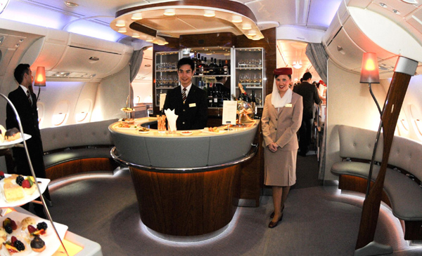 Flight attendants pose in the bar connecting the first class and business class of Emirates&apos; Airbus A380 which arrives at the Capital International Airport in Beijing August 1, 2010. [Xinhua]