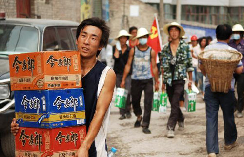 A man carries relief materials distributed by local government in mudslide-hit Zhouqu county, Gannan Tibetan autonomous prefecture in Northwest China&apos;s Gansu province, August 11, 2010. [Xinhua]