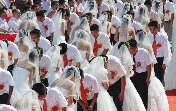 Couples hold a group wedding ceremony in Lushan county, Central China&apos;s Henan province, Aug 16, 2010. A total of 77 pairs of newlyweds announced their marriage at the ceremony in Lushan during Qixi Festival, or Chinese Valentine&apos;s Day, which is the seventh day of the seventh lunar month and fell on Aug 16 this year. [Xinhua]