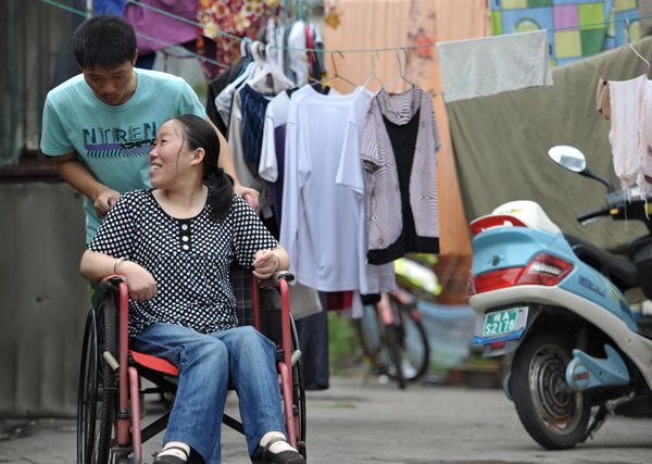 Student Jin Shujia talks to his mother while pushing her in a wheel chair in Hefei, East China&apos;s Anhui province, Sept 12, 2010. 