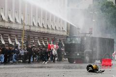 Police use water cannon to disperse protesters outside the prime minister's office in Tirana, Albania, Jan. 21, 2011. Two people were killed from firearms after a protest rally by Albania's opposition Socialist Party turned into a riot in front of the government building for three hours before the protesters disbanded. [Yang Ke/Xinhua]