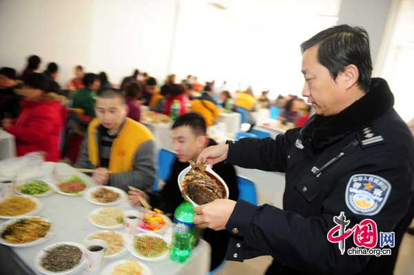 Police officers prepare dinner for prisoners and their family on Jan 25 at Haidian detention house in Beijing. [Photo/CFP]