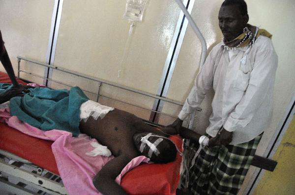 A man stands by his relative, who was injured during fighting, at Medina hospital, Mogadishu, Somalia, Monday Jan. 31, 2011. Fighting between Somali government troops and police killed scores of people in Somalia&apos;s capital on Monday, witnesses said. [Xinhua/AFP] 