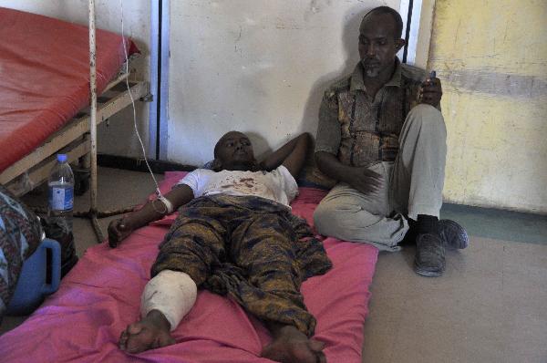 A man stands by his relative, who was injured during fighting, at Medina hospital, Mogadishu, Somalia, Monday Jan. 31, 2011. Fighting between Somali government troops and police killed scores of people in Somalia&apos;s capital on Monday, witnesses said. [Xinhua/AFP]