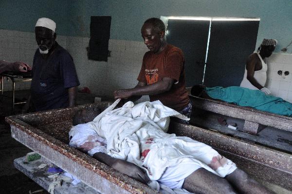 A man cleans a body at Medina hospital, Mogadishu, Somalia, Monday Jan. 31, 2011. Fighting between Somali government troops and police killed scores of people in Somalia&apos;s capital on Monday, witnesses said. [Xinhua/AFP]