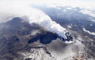 An aerial view shows Shinmoedake peak erupting between Miyazaki and Kagoshima prefectures January 31, 2011. More than 1,000 people is southern Japan have been urged to evacuate as a volcano picked up its activities, spewing ashes and small rocks into air and disrupting airline operations, a municipal official said on Monday. [Xinhua]
