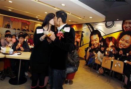 Model Kelvin Kwong and nurse Ashley Tse kiss in front of their friends and relatives during a surprise engagement bash thrown by Kelvin during Valentine's Day inside a McDonald's restaurant in Hong Kong, February 14, 2011.