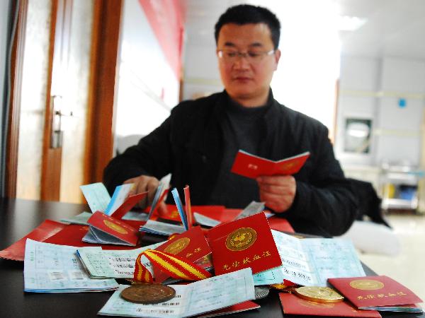 Liu Liyong shows the blood donor&apos;s books he has received for blood donation in Jiujiang, east China&apos;s Jiangxi Province, March 4, 2011. Saturday marked the beginning of a consecutive fourteenth year of Liu Liyong joining China&apos;s voluntary blood donation campaign. Liu is said to have donated more than 46,000 milliliters of blood over the past 13 years. [Xinhua] 