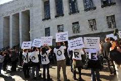 Demonstrators hold placard and wear shirts reading 'No more' in front of Milan justice court during the first hearing of the 'Ruby the Heart Stealer' case's trial on April 6, 2011. Italian Prime Minister Silvio Berlusconi's trial on charges of sex with an underage prostitute, Karima El Mahroug, nicknamed 'Ruby the Heart Stealer', and abuse of power, opened and was immediately postponded by judges to May 31. 