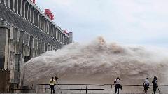 Journalists take photos as flood water is released from the Three Gorges Dam's floodgates in Yichang, in central China's Hubei province, Tuesday, July 20, 2010. [Xinhua] 