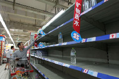 A shopper in Hangzhou, Zhejiang Province grabs a bottle of mineral water yesterday after a chemical spillage threatened the city's water supply. 