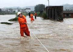 Rescue workers attempt to save people stranded by floods in Wuning county, East China's Jiangxi Province on Monday.