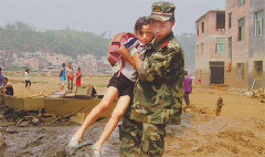 A soldier with the People's Armed Police helps a girl across a muddy field on Wednesday in Wangmo, Guizhou province, after floods ravaged the county on Sunday and Monday. A soldier with the People's Armed Police helps a girl across a muddy field on Wednesday in Wangmo, Guizhou province, after floods ravaged the county on Sunday and Monday.