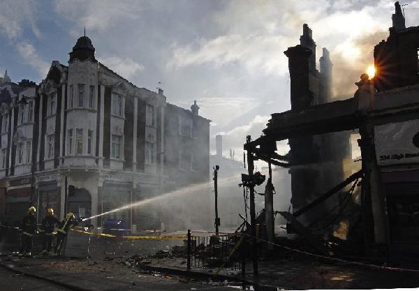 Firemen dowse down buildings set alight during riots in Tottenham, north London, August 7, 2011. [Xinhua]