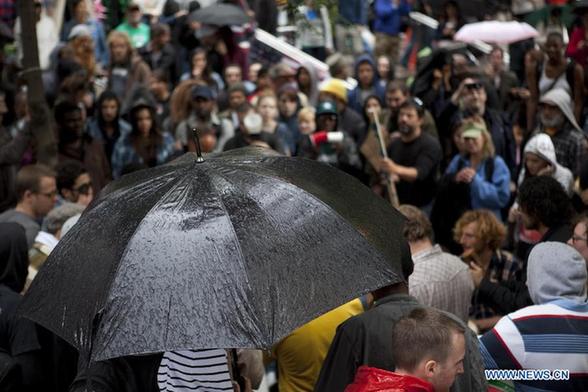 Prostesters carry on their 'Occupy Wall Street' movement in the rain near Wall Street in New York, the United States, Oct. 2, 2011. [Fan Xia/Xinhua] 