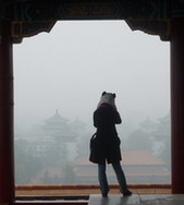 On a 'blue-sky day,' this tourist would have a clear view from the top of a hill in Jingshan Park in Beijing. But on Monday, visibility was less than 1 kilometer. [China Daily] 
