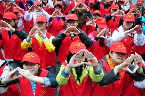 Student volunteers present red banners during an HIV prevention campaign in Nanchong, southwest China's Sichuan Province, Nov. 29, 2011. Falling on Dec. 1, the World AIDS Day has its theme of 'Getting to Zero' this year. [Photo/Xinhua]     