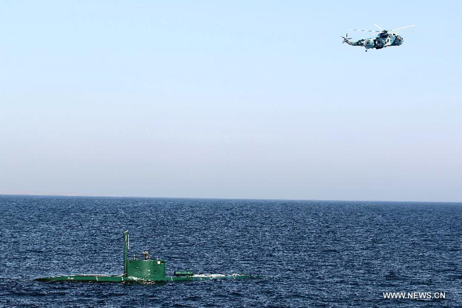 A helicopter and submarine are seen during Iranian naval maneuvers dubbed Velayat 90 on the Sea of Oman, Iran, Dec. 27, 2011. The Iranian Navy launched 10-day massive naval exercises in the international waters on Saturday. The naval drills, dubbed Velayat 90, cover an area of 2,000 km stretching from the east of the Strait of Hormuz in the Persian Gulf to the Gulf of Aden.[Ali Mohammadi/Xinhua]