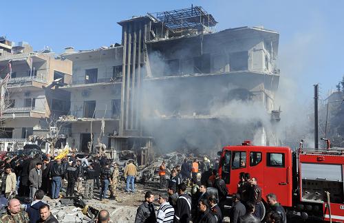 A handout picture released by the official Syrian Arab News Agency (SANA) on March 17, 2012, shows Syrian fire fighters working at the scene of two bomb attacks on security buildings in the heart of the Syrian capital Damascus which killed several people, state television said. [Xinhua/AFP] 