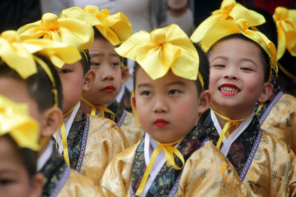Pupils acting as ancient boy servants recite the analects of Confucius during the spring sacrificing ceremony for Confucius in Tianjin, north China, April 29, 2012. [Photo/Xinhua]