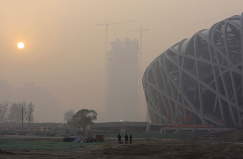 Buildings are shrouded in haze and smog nearby Beijing National Stadium. [File photo] 