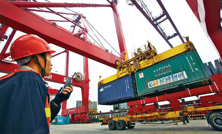 Containers being loaded at a dock in Haikou, capital city of Hainan province.