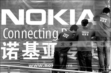 Workers put up a new Nokia advertisement on the front of an electronics mall in Beijing. 