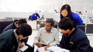 An Indian employee talks with Chinese coworkers in an institute in Shandong Province. More foreigners are employed by China-based companies in these years. 