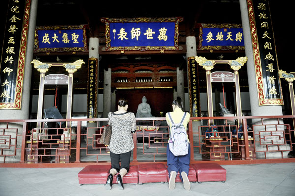 A student and her mother pray for good luck in the coming gaokao, or college entrance exam, at the Confucian Temple in Fuzhou, Fujian province, on Thursday. [China Daily]
