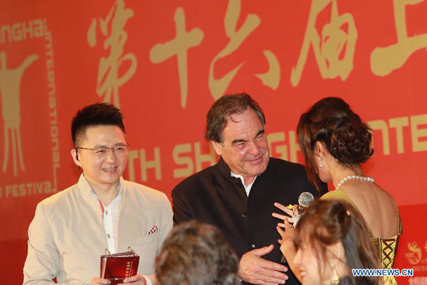 U.S. director Oliver Stone (C) is interviewed on the red carpet for the opening ceremony of the 16th Shanghai International Film Festival in Shanghai, east China, June 15, 2013. [Pei XinXinhua] 