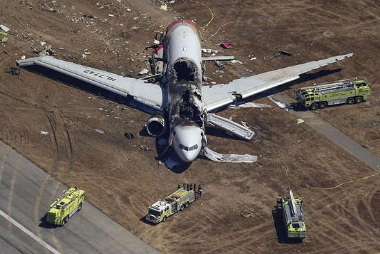 Firefighters surround an Asiana Airlines Boeing 777 plane after it crashed while landing at San Francisco International Airport in California on July 6, 2013. [Agencies]